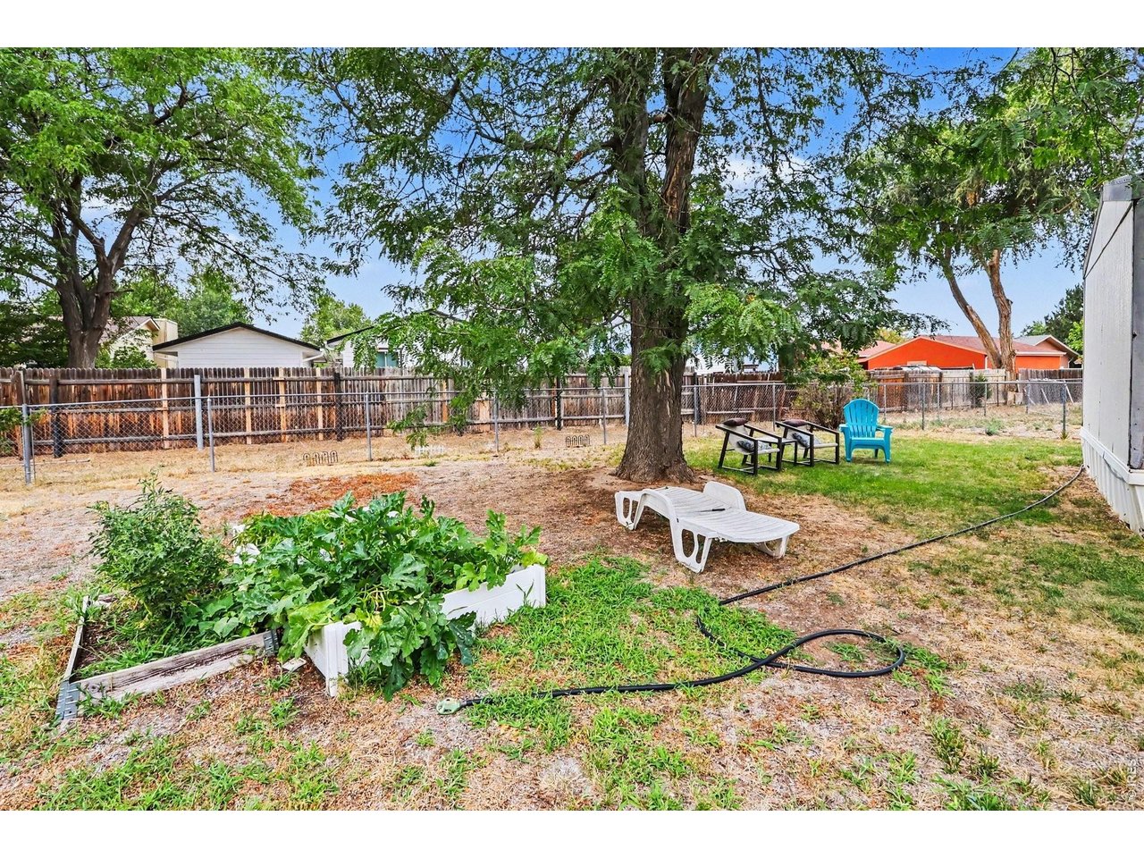 1401 9th Street, Unit 159 Fort Lupton, CO 80621 - Photo 16 of 24 Backyard showing the large shade tree and garden area.