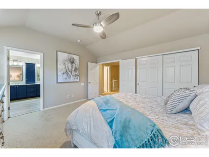 a bedroom with a large bed and a chandelier