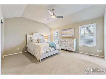 a bed room with a bed and a ceiling fan