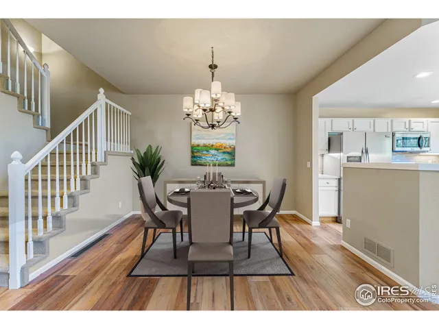a dining room with furniture a chandelier and wooden floor