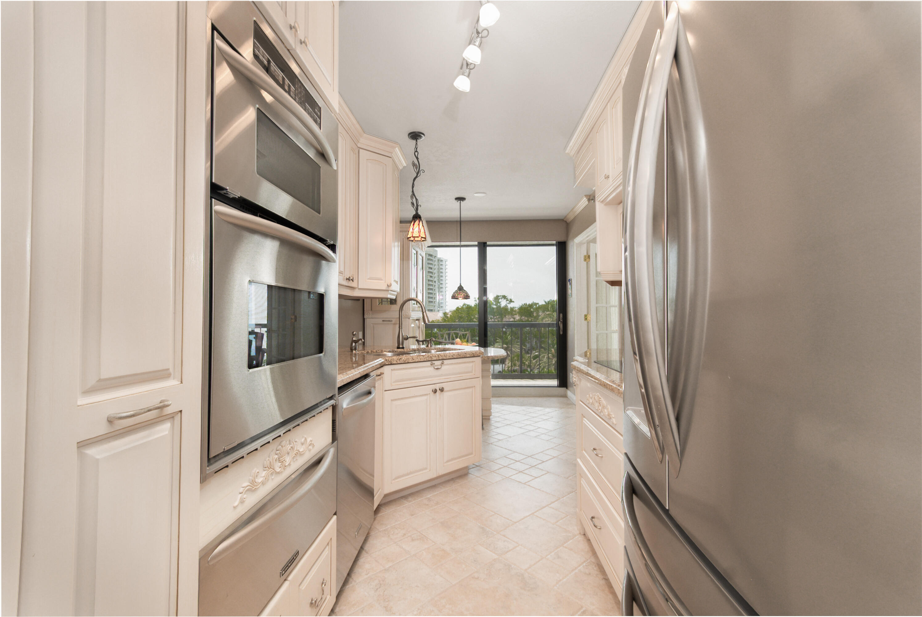 4748 South Ocean Boulevard, Unit 4B Highland Beach, FL 33487 - Photo 18 of 56 a large white kitchen with stainless steel appliances granite countertop a refrigerator and a stove