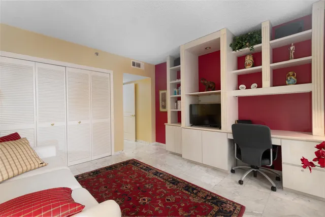 a bedroom with a bed and large windows