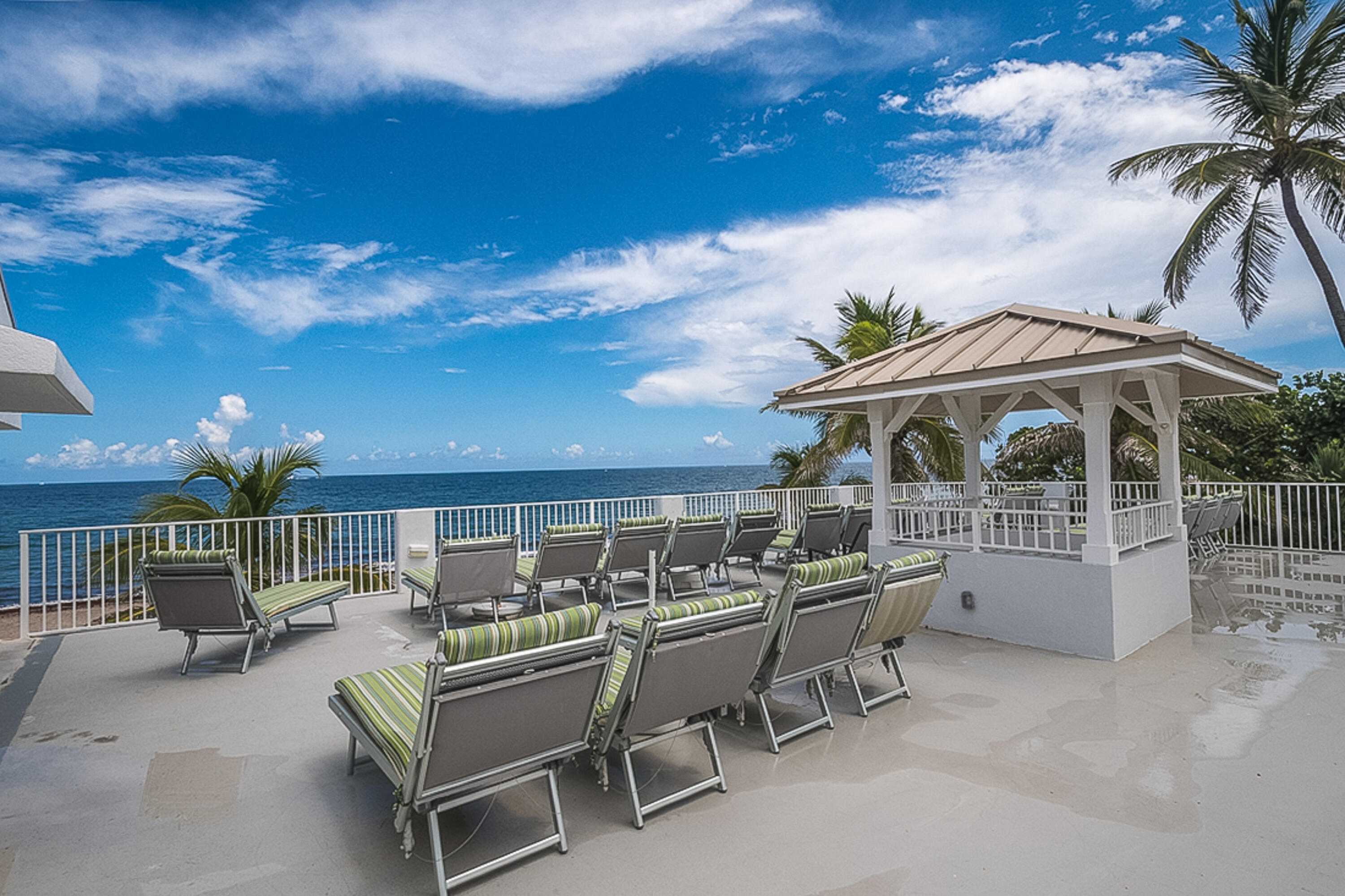4748 South Ocean Boulevard, Unit 4B Highland Beach, FL 33487 - Photo 46 of 56 an outdoor sitting area with furniture and umbrella