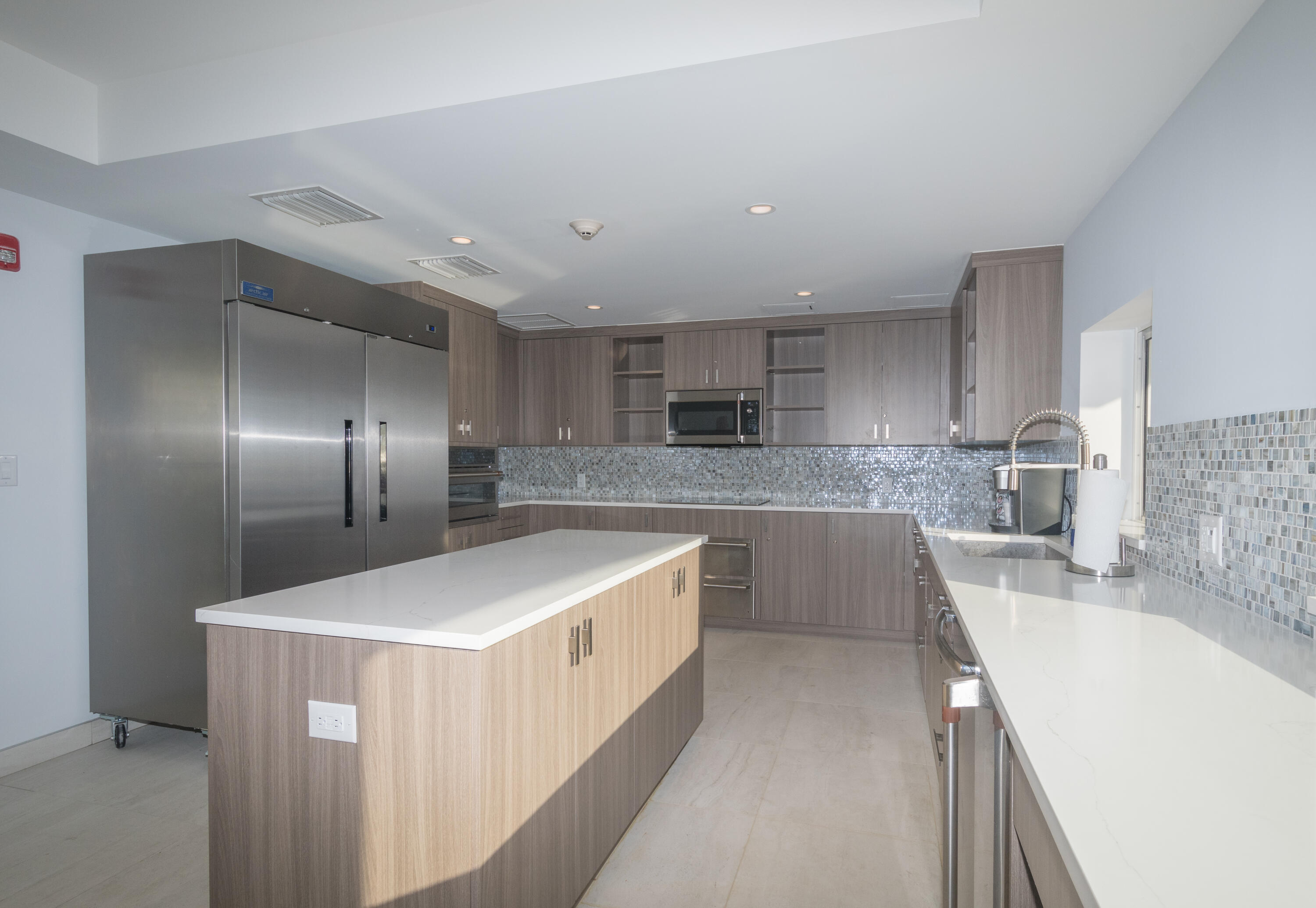 4748 South Ocean Boulevard, Unit 4B Highland Beach, FL 33487 - Photo 52 of 56 a large kitchen with stainless steel appliances kitchen island granite countertop a sink and cabinets