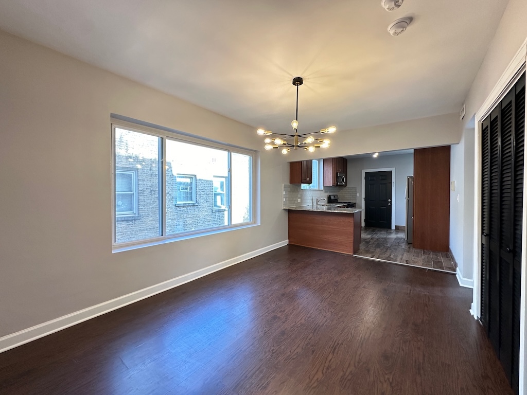 2617 West Rascher Avenue, Unit 2 Chicago, IL 60625 - Photo 8 of 20 a view of a big room with wooden floor chandeliers and kitchen