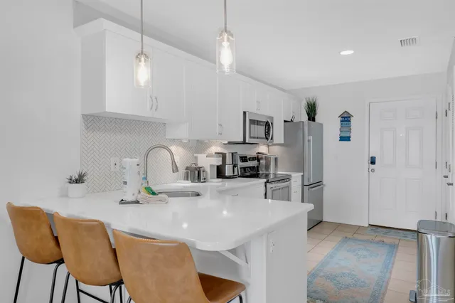 a kitchen with kitchen island a stove a table and chairs in it