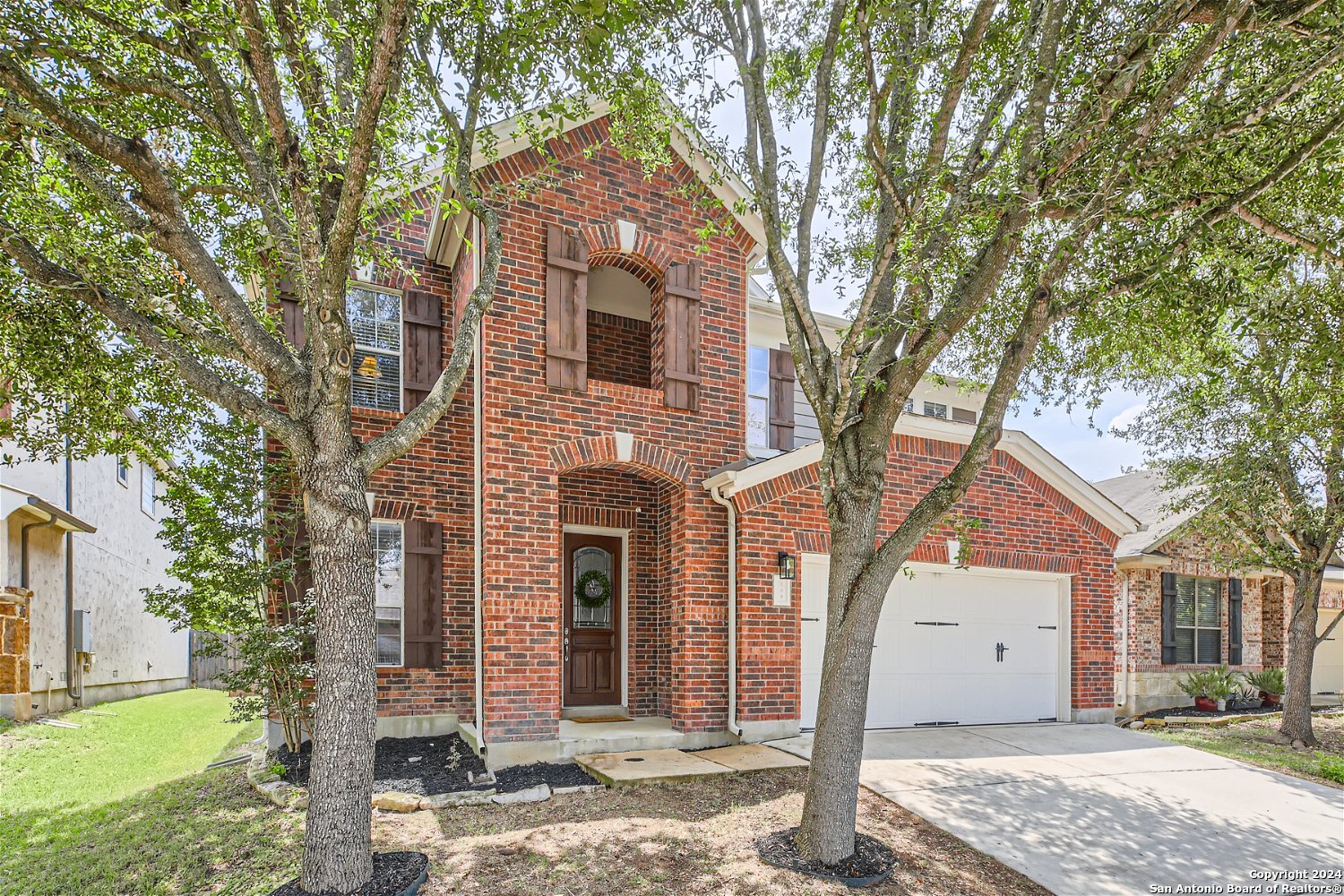 a front view of a house with a tree