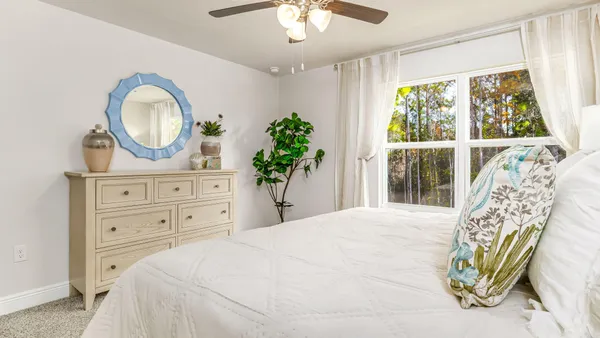 a bedroom with a bed mirror and a window