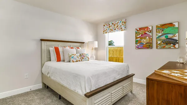 a bedroom with a bed and painting on the wall