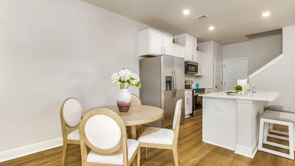 a kitchen with a dining table chairs and refrigerator