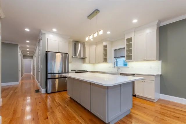 a kitchen with stainless steel appliances granite countertop a sink a refrigerator and a stove