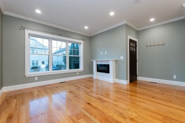a view of empty room with wooden floor and fireplace