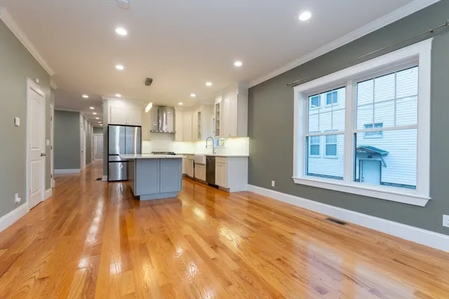 a view of kitchen with kitchen island wooden floor and center island