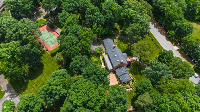 an aerial view of residential house with outdoor space and trees all around