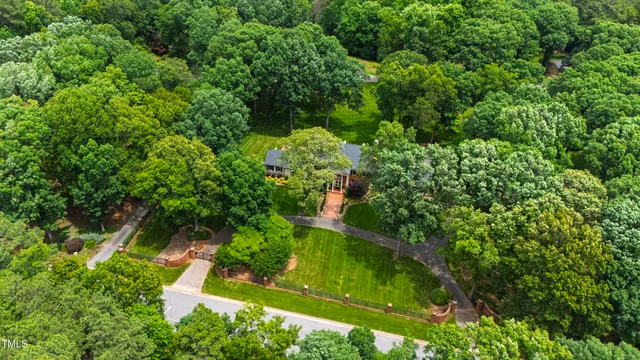 an aerial view of residential house with outdoor space and trees all around