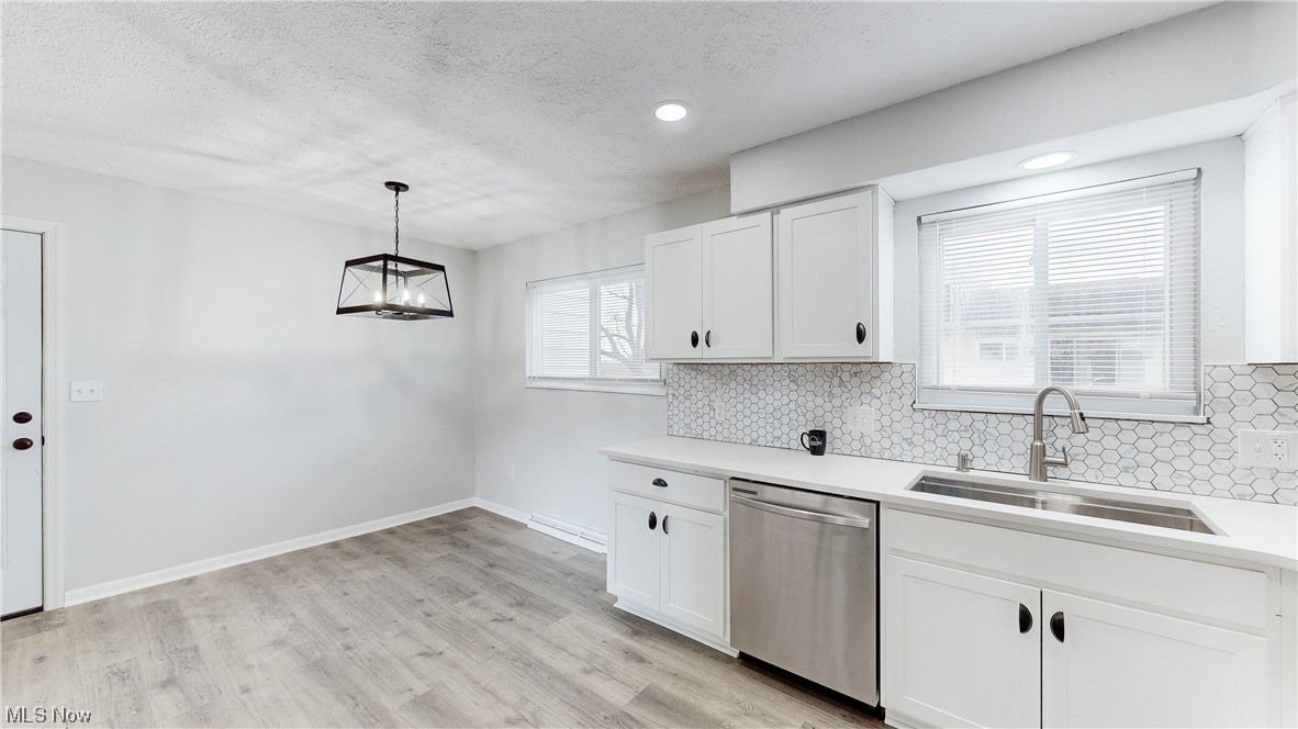 1466 Scenic Way Akron, OH 44310 - Photo 10 of 35 Kitchen with hanging light fixtures, dishwasher, white cabinetry, and light hardwood / wood-style floors