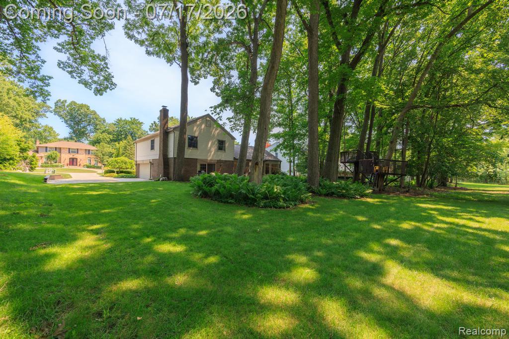 1648 North Kilburn Road Rochester, MI 48306 - Photo 35 of 41 Expansive green lawn with a mature tree backdrop, featuring a treehouse structure