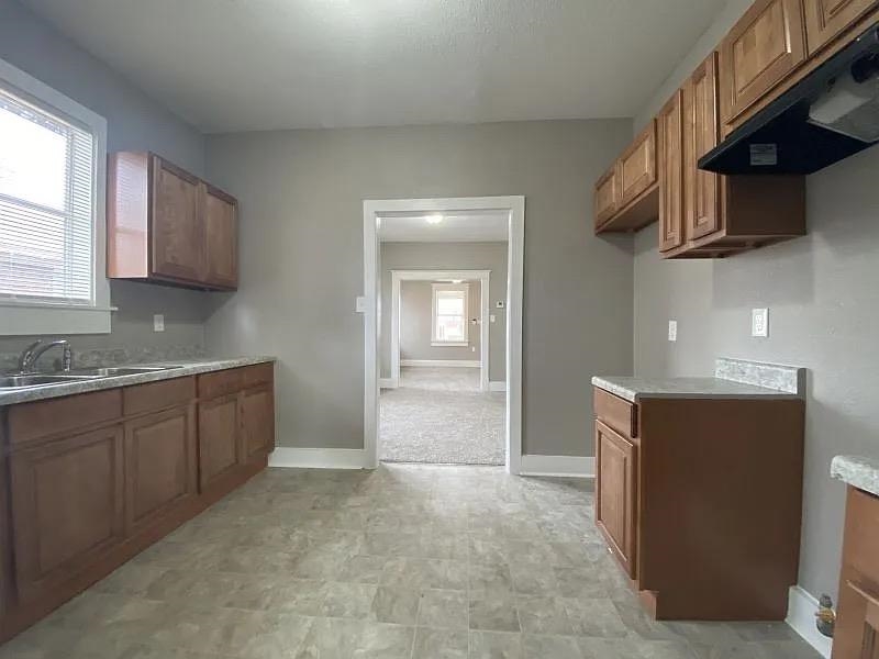 1487 Swift Street Memphis, TN 38109 - Photo 7 of 8 a kitchen with stainless steel appliances granite countertop a sink stove and microwave