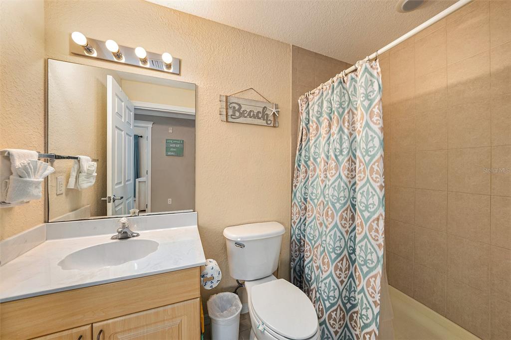 13999 Gulf Boulevard, Unit 406 St. Petersburg, FL 33708 - Photo 21 of 35 a bathroom with a sink a toilet and a mirror