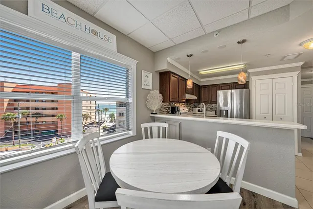 a kitchen with a table chairs refrigerator and cabinets