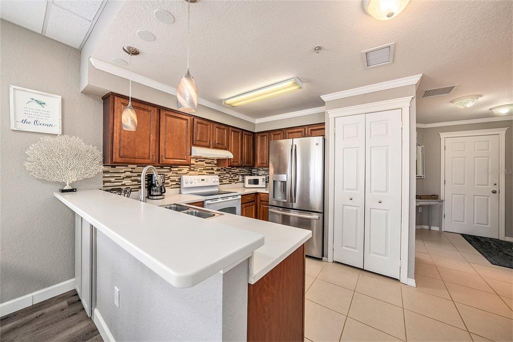 13999 Gulf Boulevard, Unit 406 St. Petersburg, FL 33708 - Photo 9 of 35 a kitchen with a sink a refrigerator and cabinets