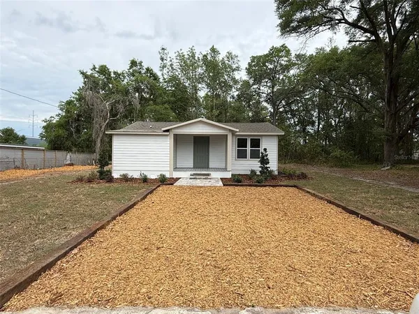 a front view of house with yard and trees around