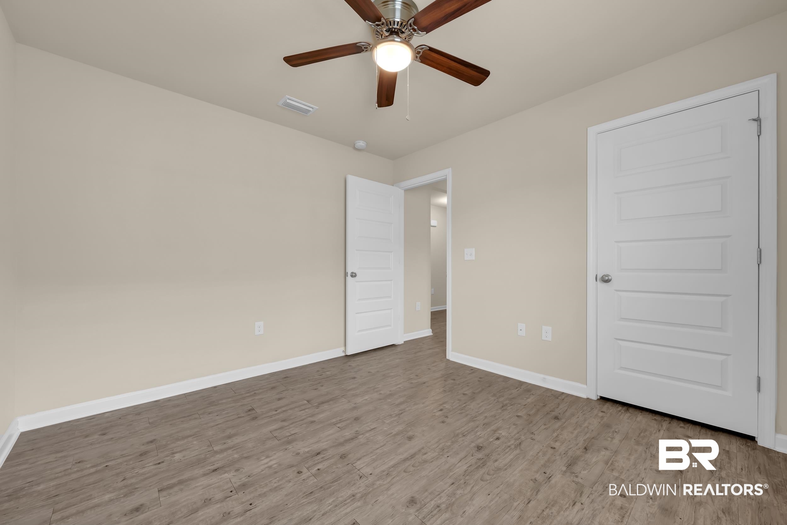 17344 Harding Drive Foley, AL 36535 - Photo 22 of 46 Neutral wall tones with crisp white trim, featuring wood-finish flooring, a ceiling fan, and panel doors