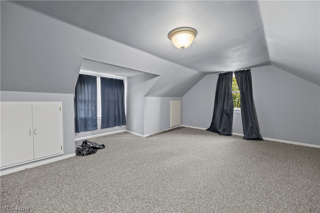 9988 West Ridge Road Elyria, OH 44035 - Photo 34 of 49 Gray walls with textured carpeting, featuring two windows, built-in cabinetry, and a ceiling-mounted light fixture