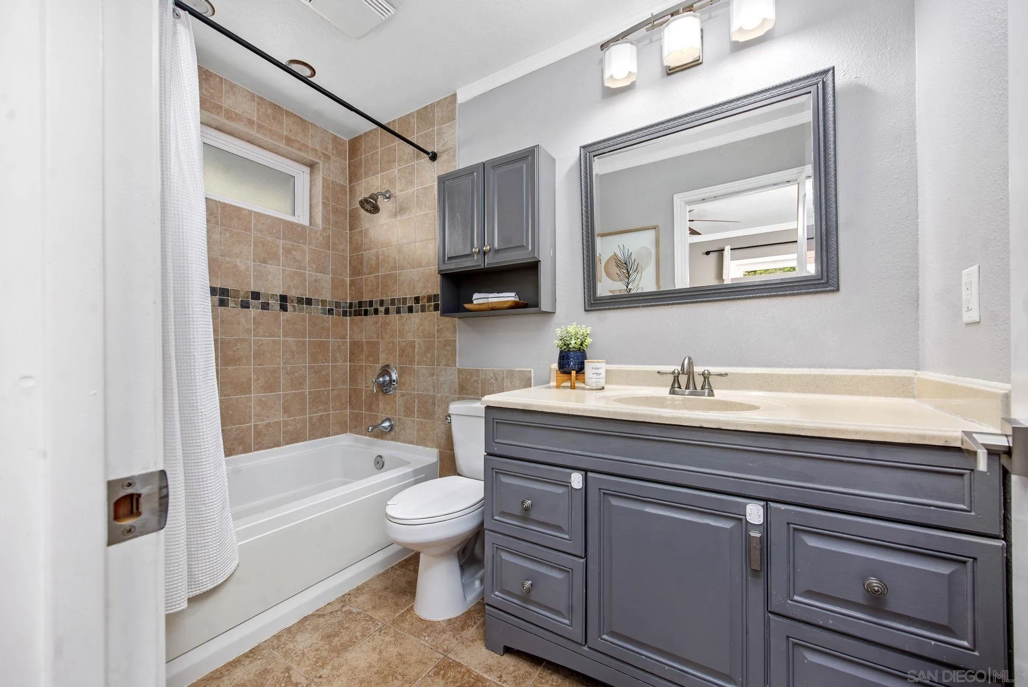 1311 Ramona Avenue Spring Valley, CA 91977 - Photo 15 of 33 a bathroom with a granite countertop sink a toilet mirror and bathtub
