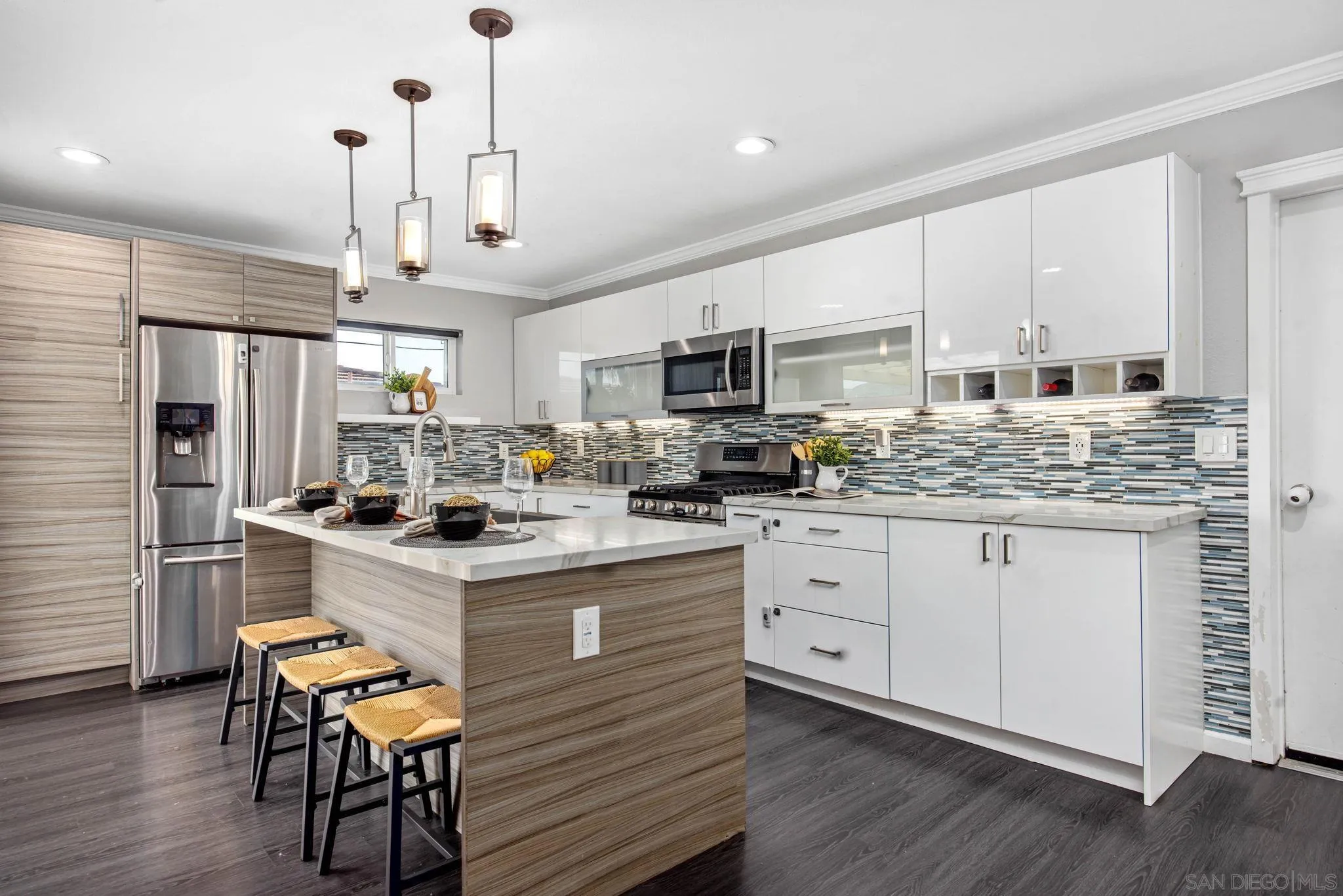 1311 Ramona Avenue Spring Valley, CA 91977 - Photo 5 of 33 a kitchen with stainless steel appliances kitchen island granite countertop a stove a sink dishwasher a refrigerator and white cabinets with wooden floor