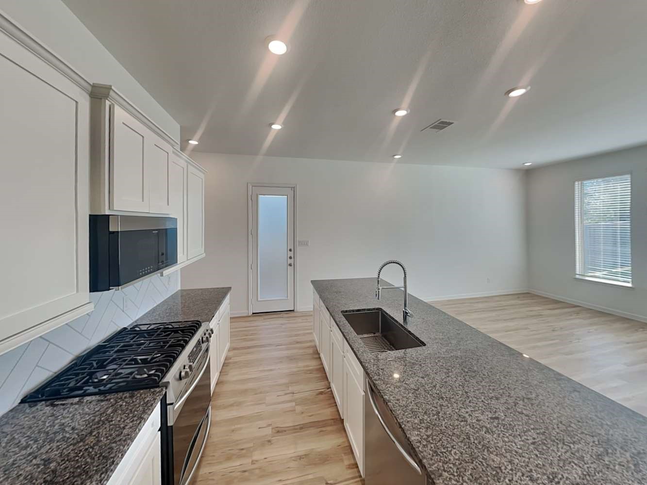 4026 Champlain Way Iowa Colony, TX 77583 - Photo 9 of 17 a kitchen with granite countertop a sink and a stove top oven