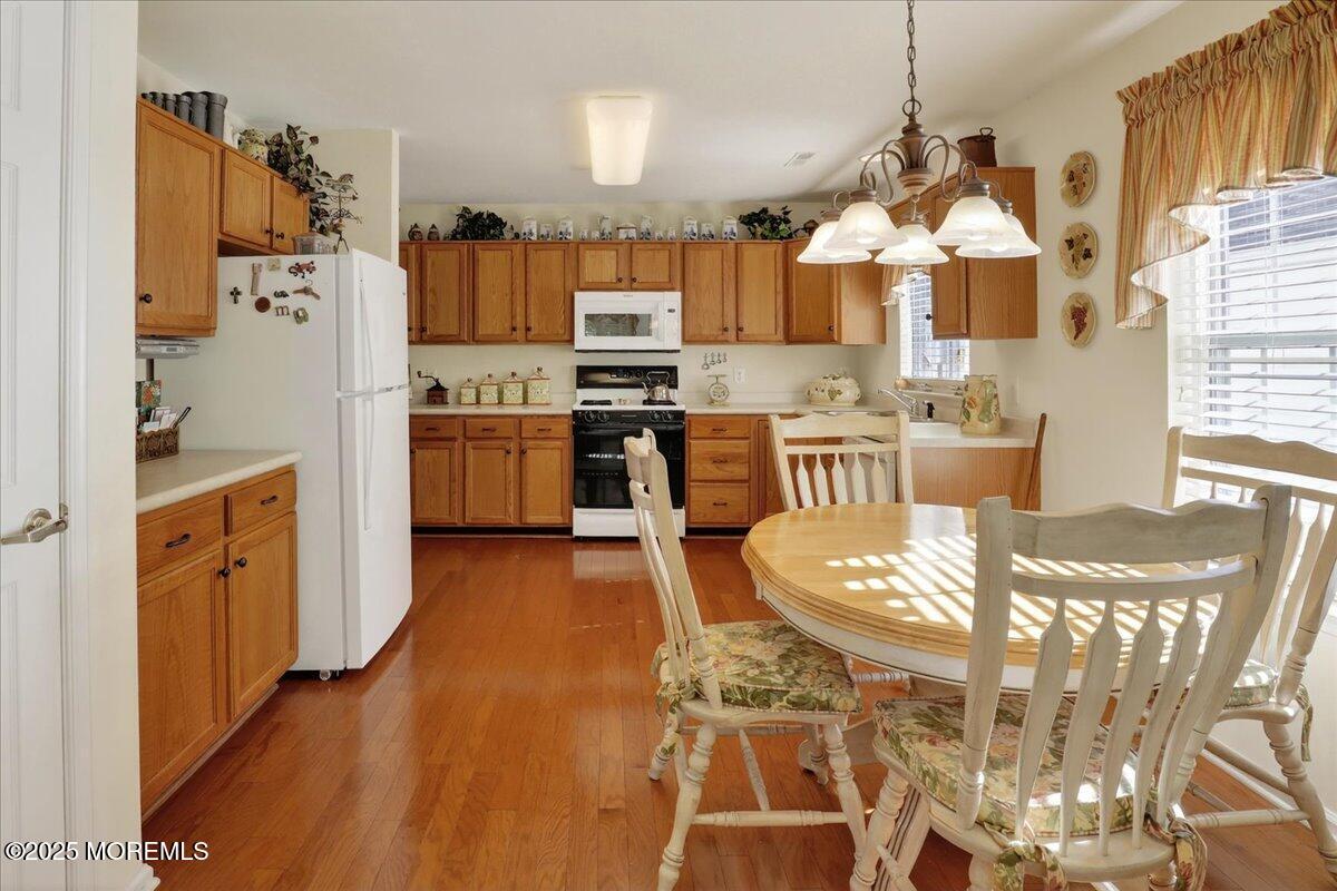 54 Merion Lane Jackson, NJ 08527 - Photo 13 of 46 a kitchen with stainless steel appliances granite countertop a stove top oven a sink a dining table and chairs with wooden floor