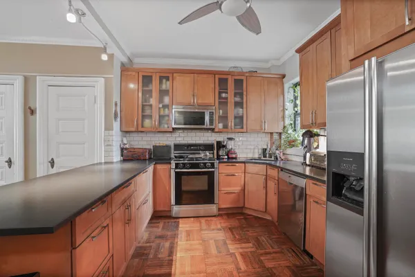 a large kitchen with stainless steel appliances granite countertop a stove sink and refrigerator