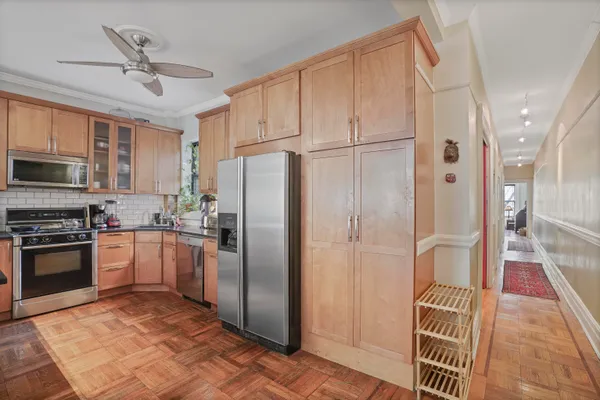 a kitchen with stainless steel appliances granite countertop a refrigerator a stove and a sink with cabinets