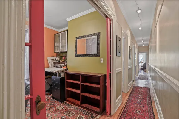 a view of hallway with a rug and a dresser