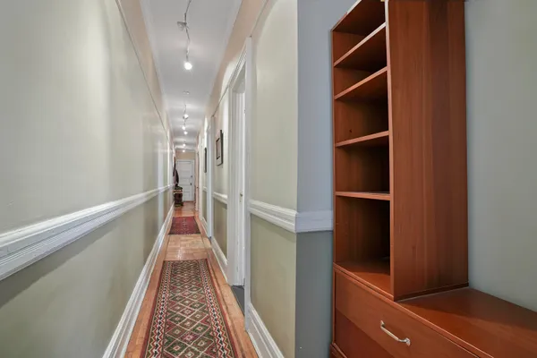 a view of hallway with stairs and wooden floor