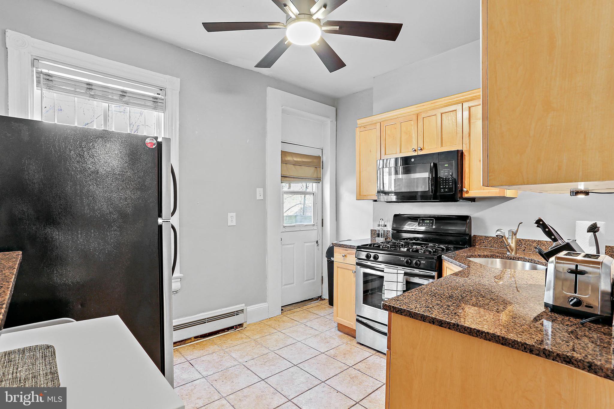 1211 33rd Street Northwest, Unit 1 Washington, DC 20007 - Photo 14 of 18 a kitchen with stainless steel appliances granite countertop a refrigerator a stove and a sink with wooden floor