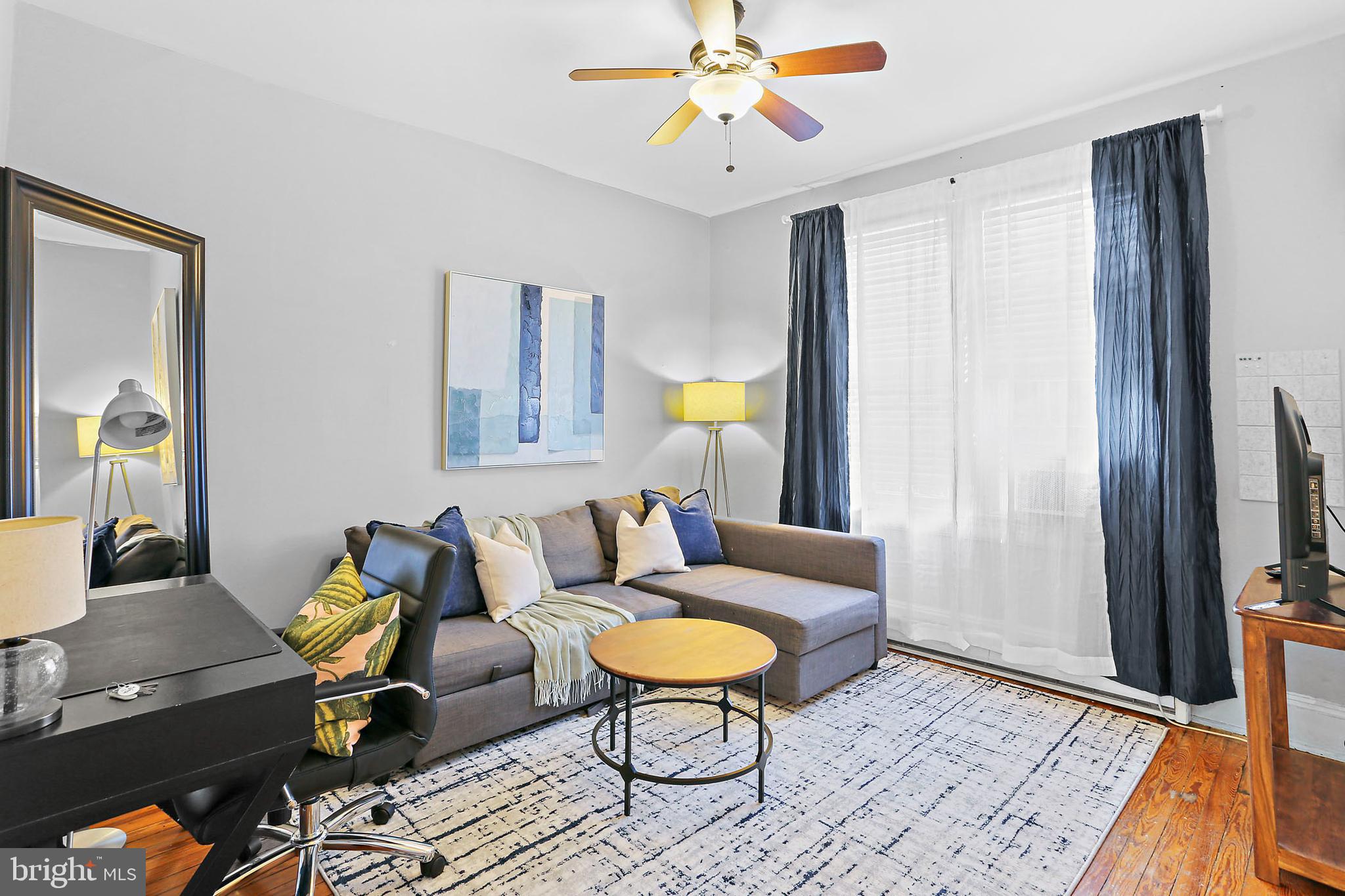 1211 33rd Street Northwest, Unit 1 Washington, DC 20007 - Photo 5 of 18 a living room with furniture a dining table and a lamp with wooden floor