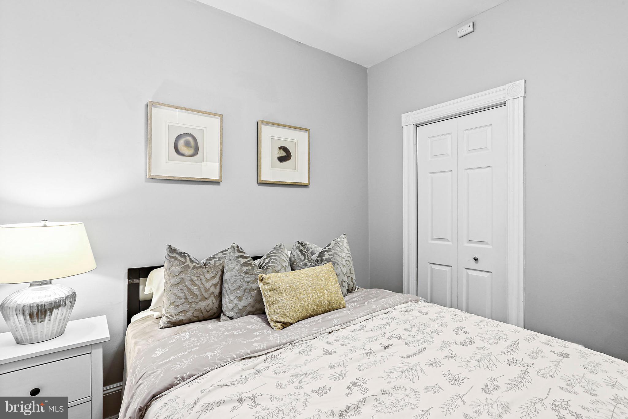 1211 33rd Street Northwest, Unit 1 Washington, DC 20007 - Photo 9 of 18 a bedroom with a bed and a lamp on dresser