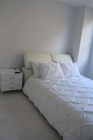 a large white bed in a white room