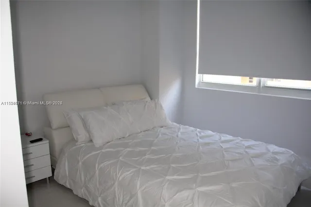 a bedroom with two beds and a large window