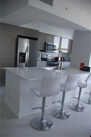 a kitchen with stainless steel appliances a refrigerator sink and window