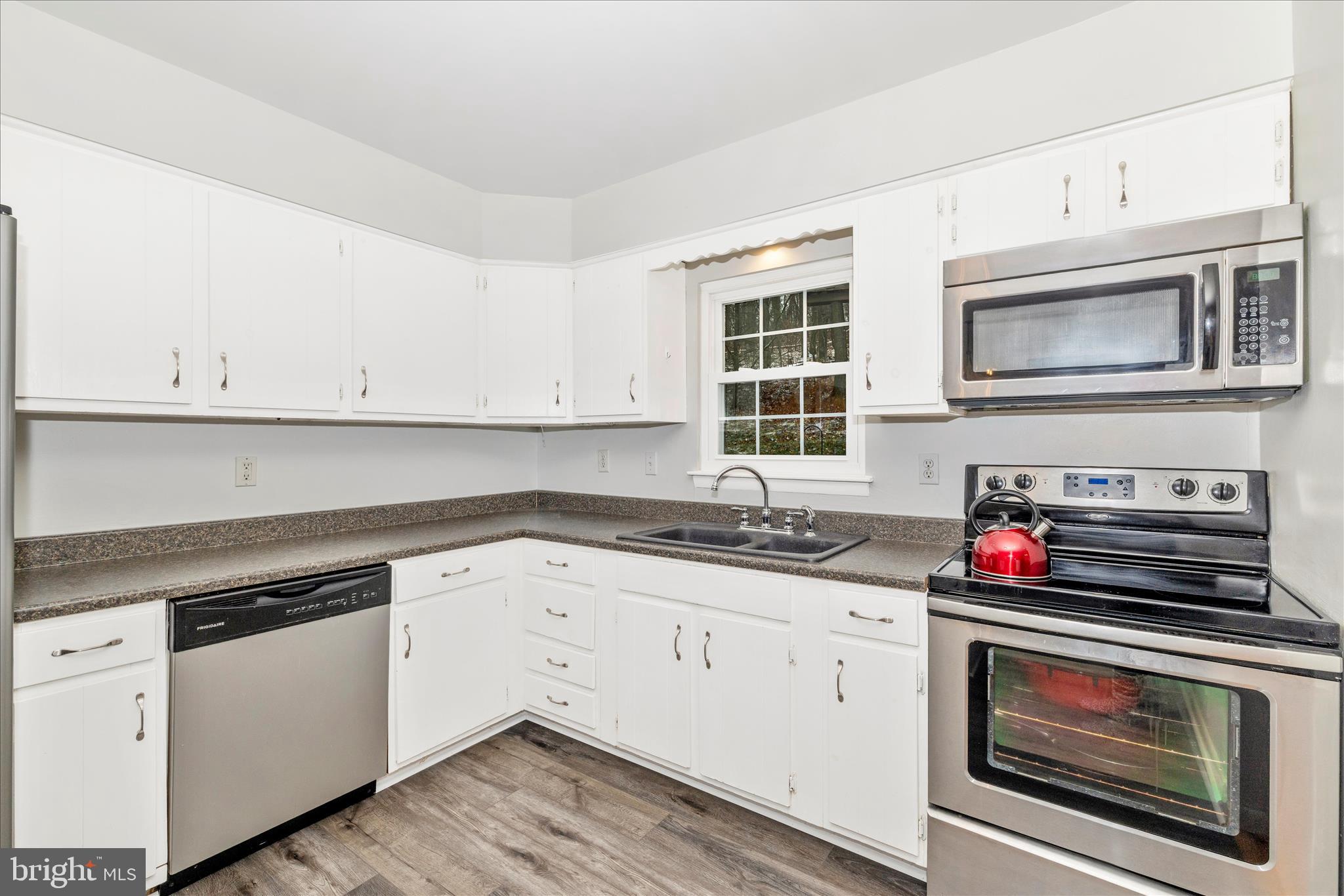 2235 Bowersox Road New Windsor, MD 21776 - Photo 11 of 35 a kitchen with granite countertop cabinets stainless steel appliances and wooden floor