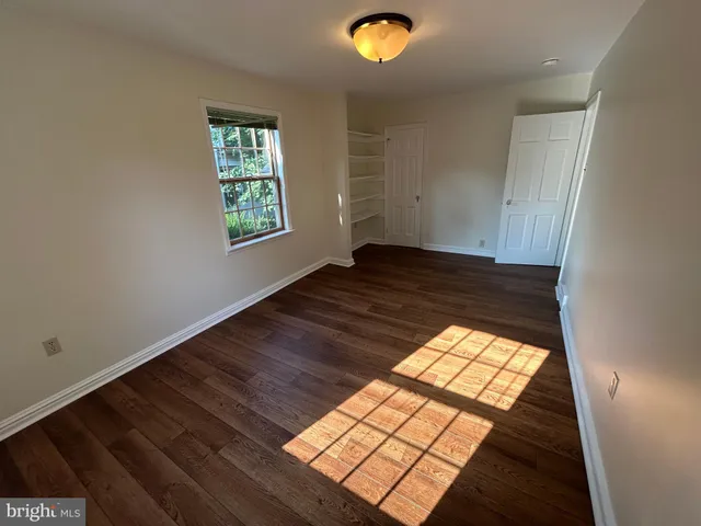an empty room with wooden floor windows and view
