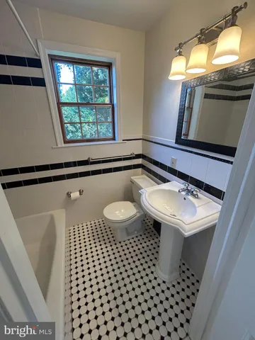 a bathroom with a sink a toilet and a window