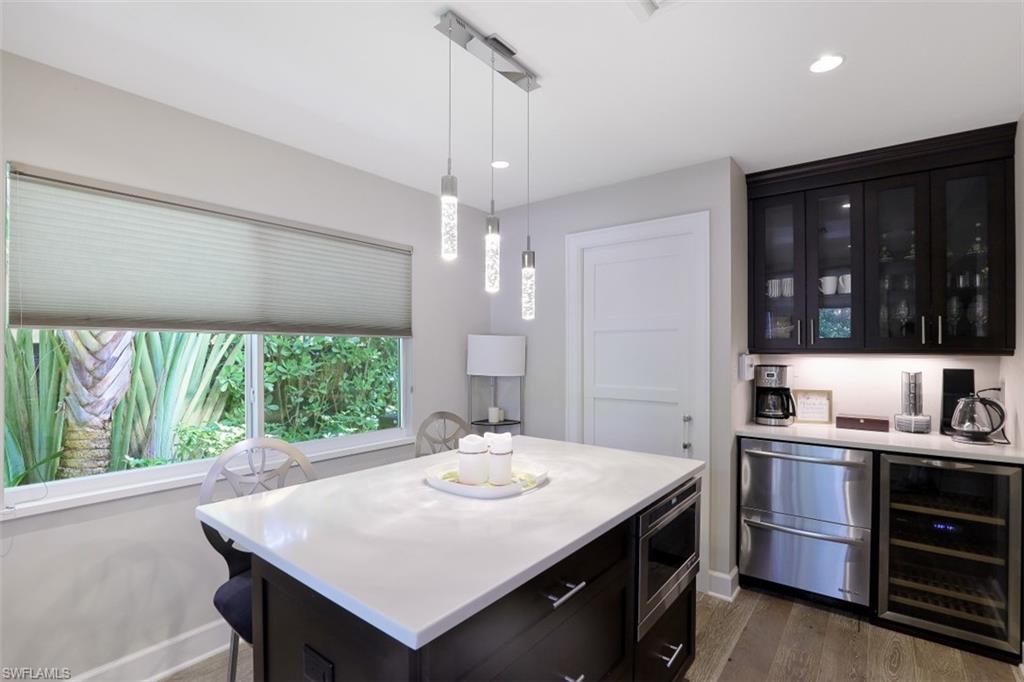 1199 9th Avenue North Naples, FL 34102 - Photo 12 of 24 a kitchen with kitchen island a sink dining table and chairs