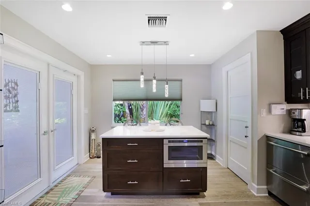 a kitchen with kitchen island a sink dining table and chairs
