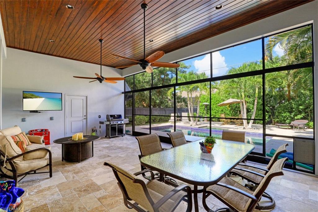 1199 9th Avenue North Naples, FL 34102 - Photo 14 of 24 a dining room with furniture large windows and wooden floor