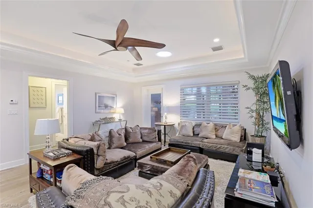 a living room with furniture a flat screen tv and a window