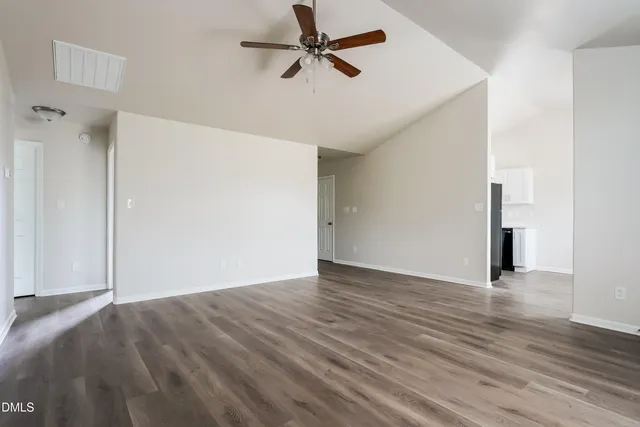 a view of empty room with wooden floor
